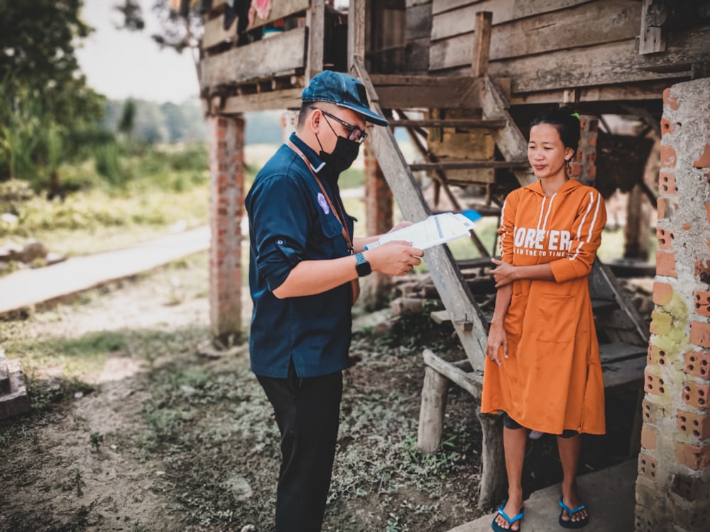 woman in orange dress holding white printer paper