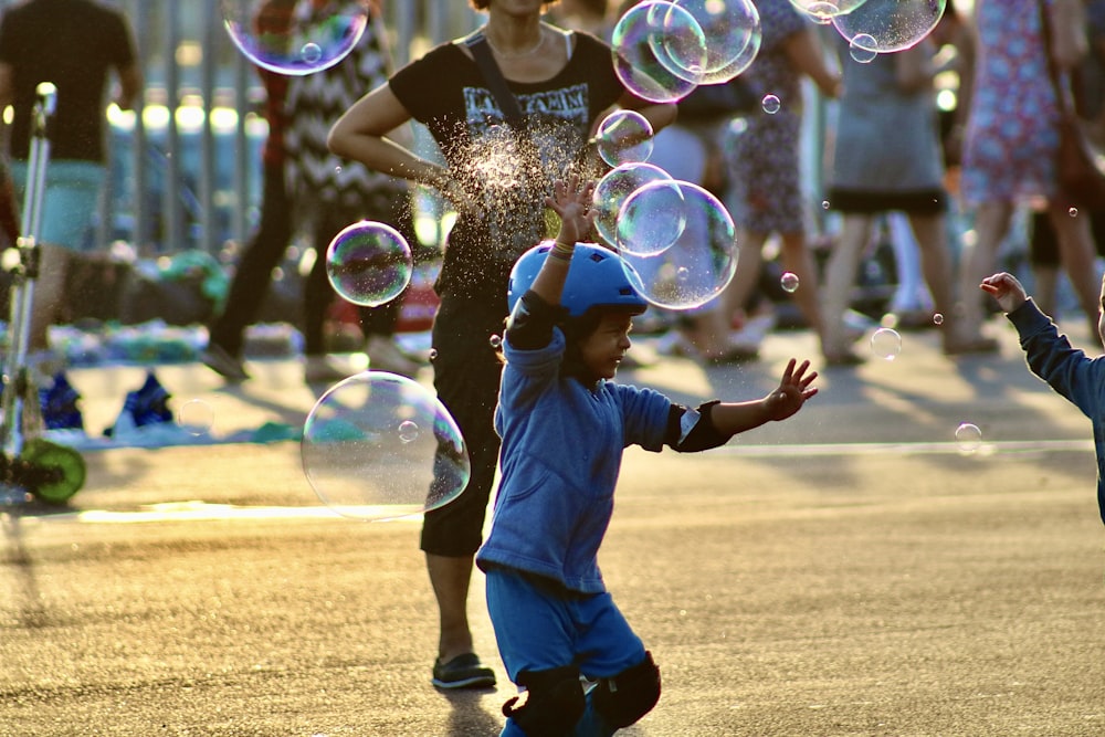 boy in blue shirt playing bubbles