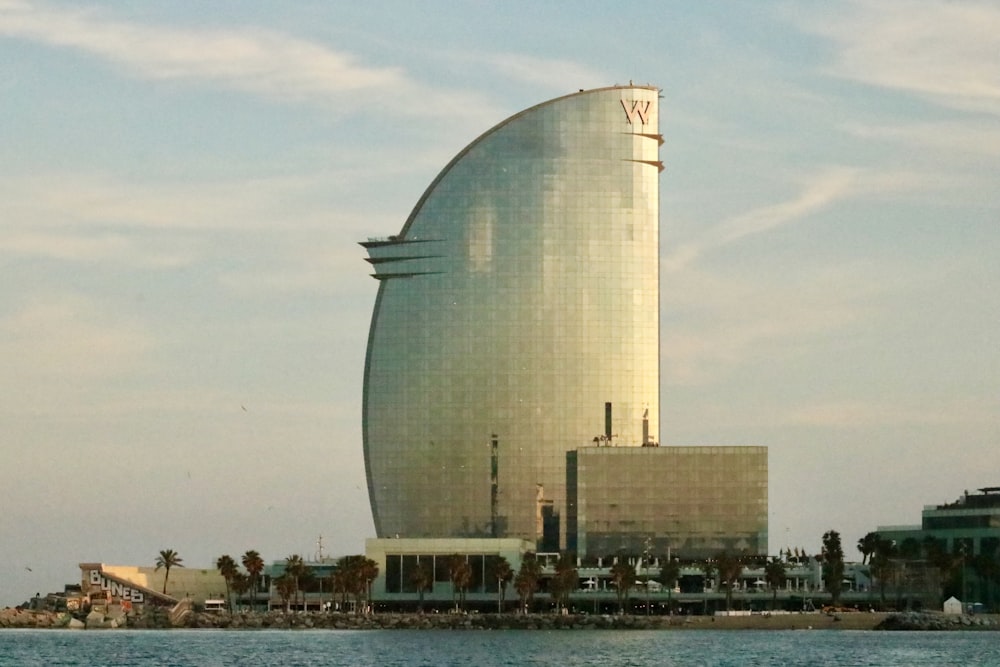 edificio in cemento bianco vicino a uno specchio d'acqua durante il giorno