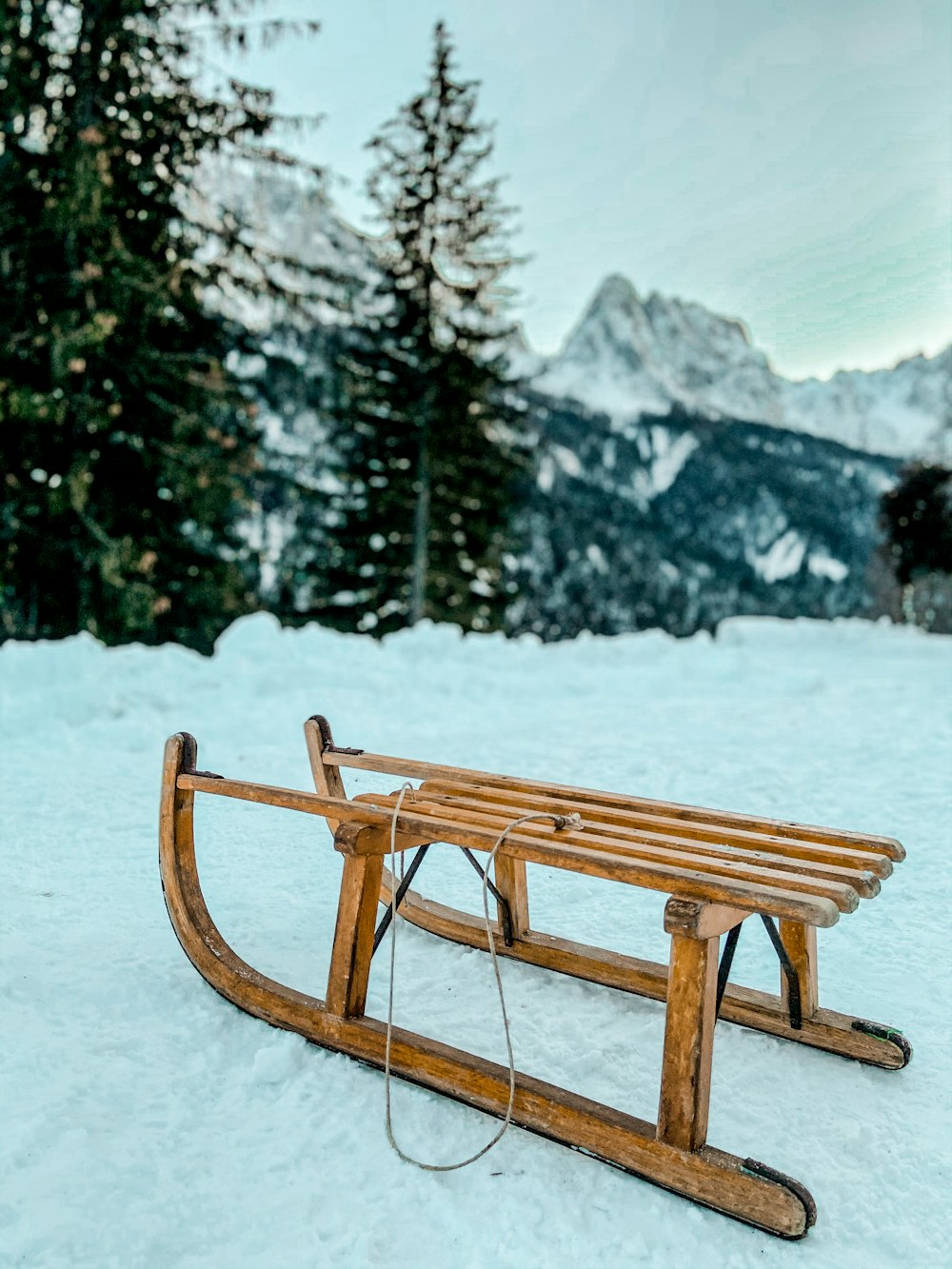 brown wooden picnic table on snow covered ground during daytime