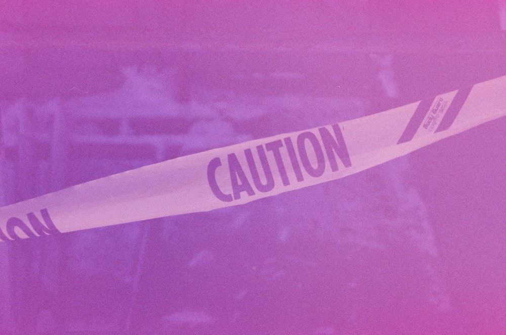 a pink and purple photo of a caution sign