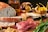 A rustic wooden table displaying various Italian artisanal food products in natural light.