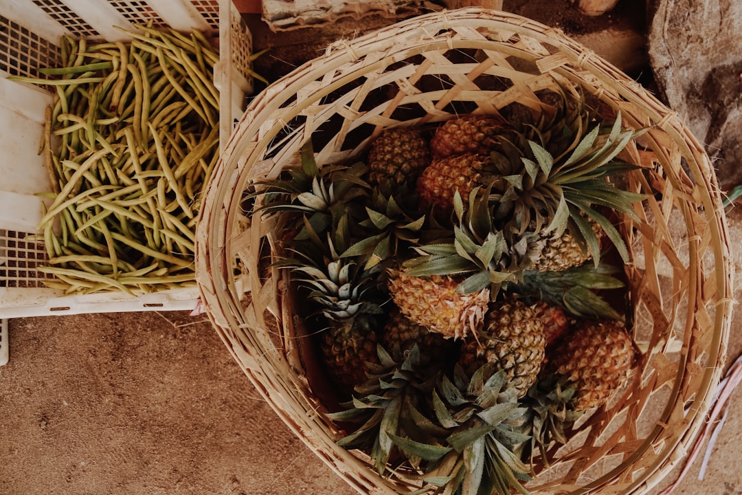 brown and green pineapple fruit on brown woven basket