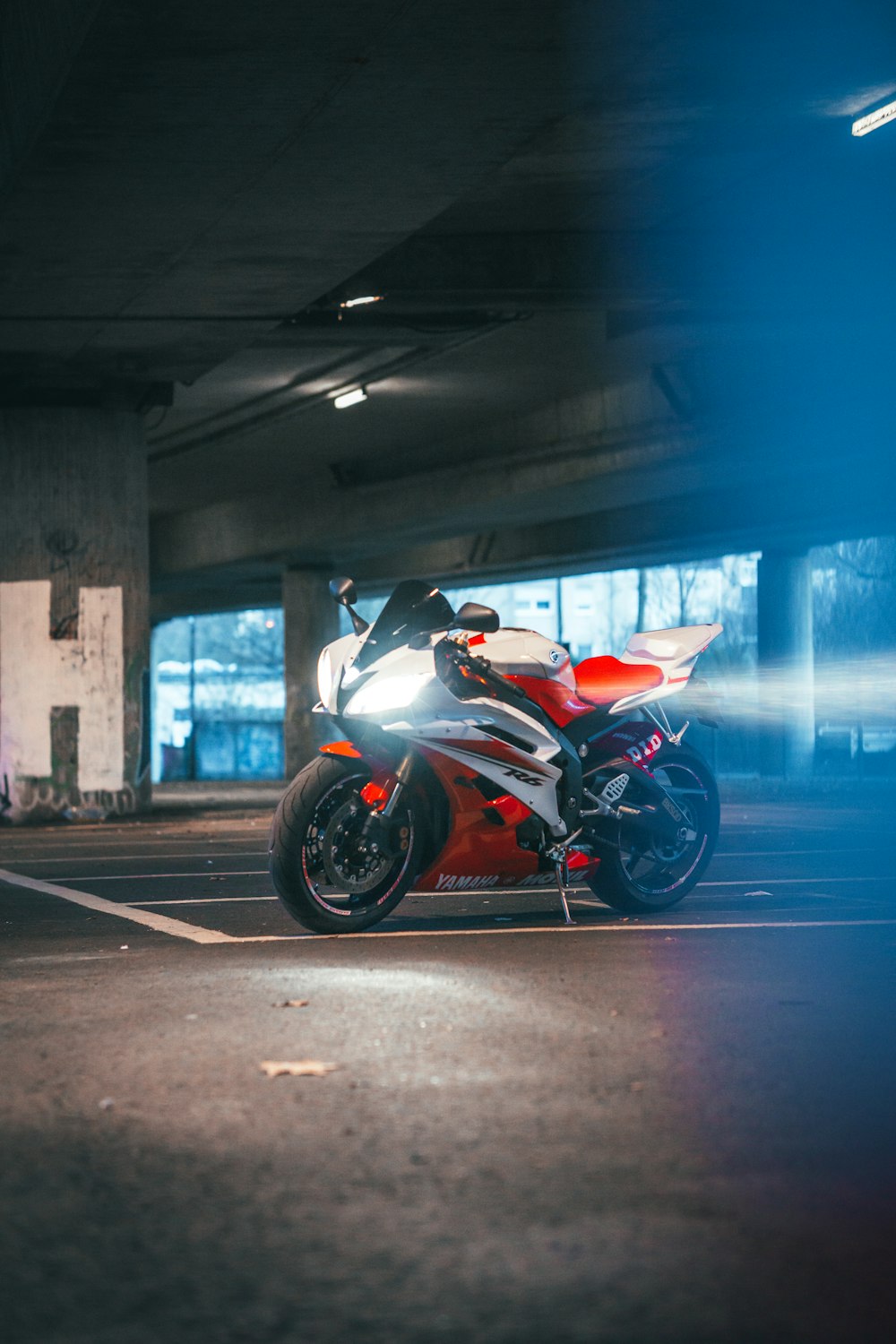 white and red sports bike parked on gray concrete road during daytime