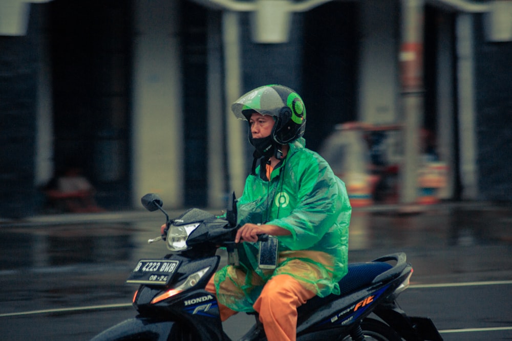 man in green jacket riding black motorcycle