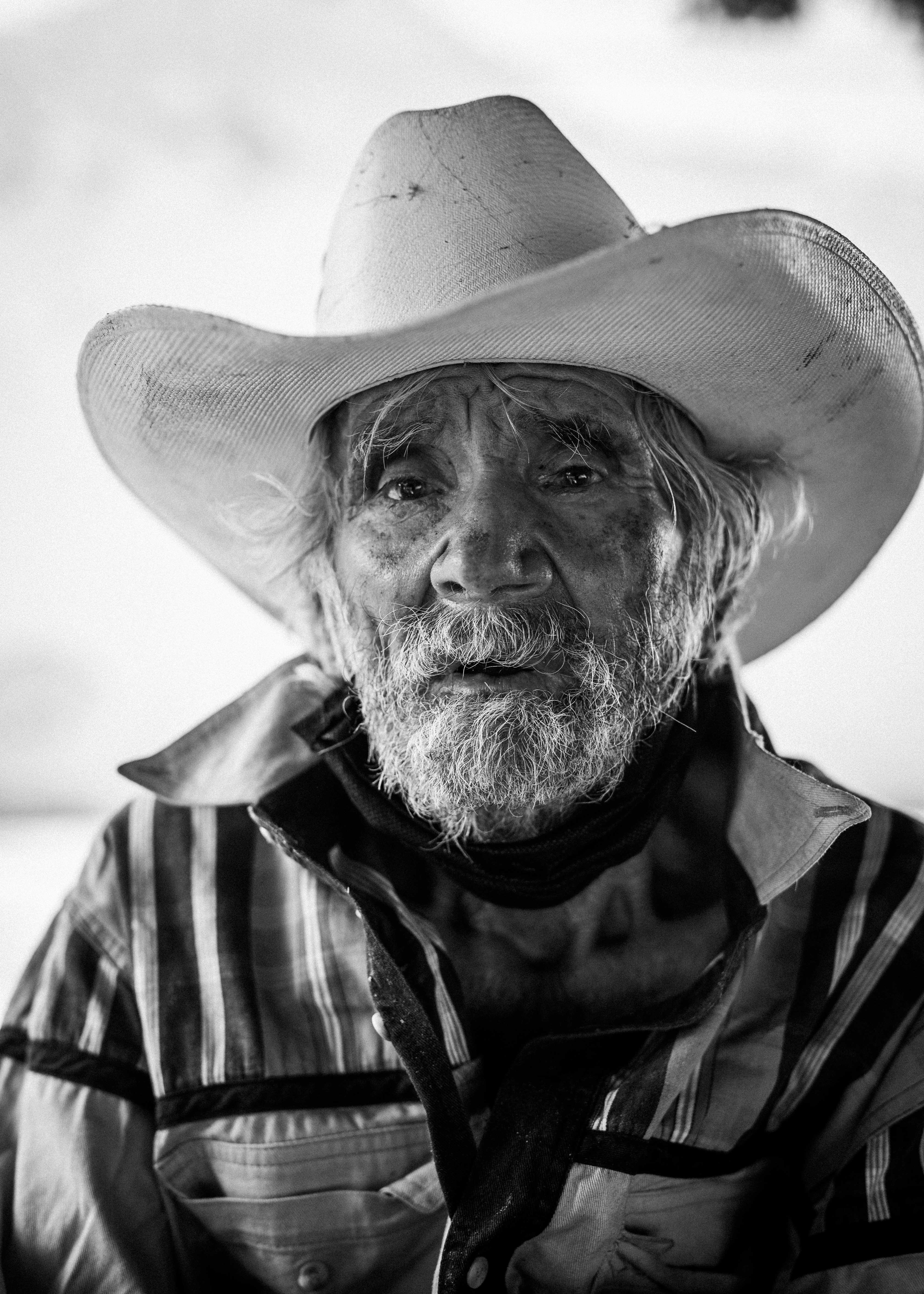 man in cowboy hat in grayscale photography