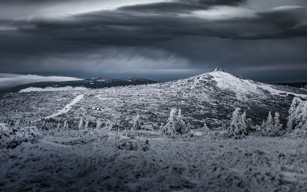 montagna innevata sotto il cielo nuvoloso durante il giorno