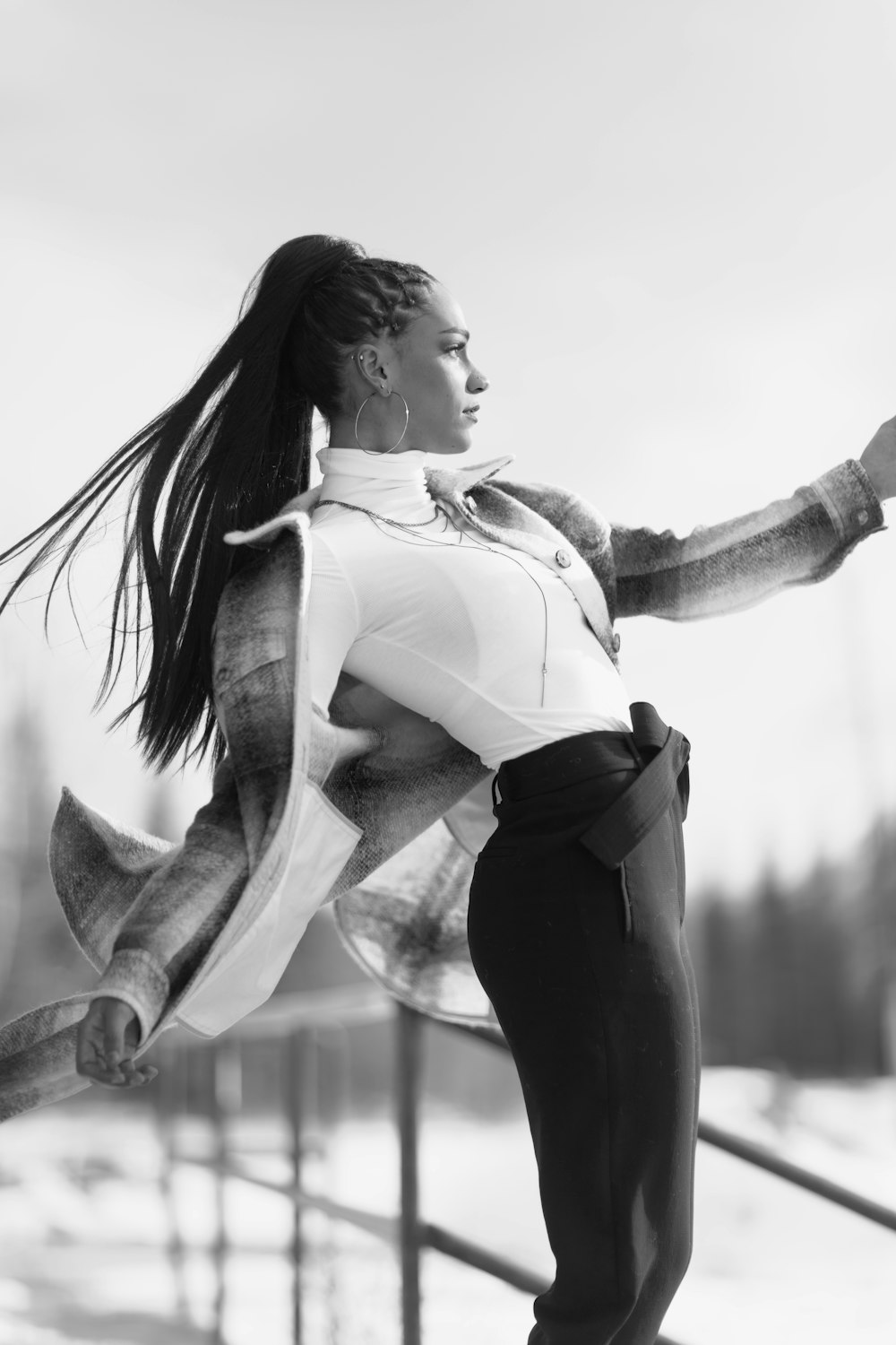 grayscale photo of woman in white long sleeve shirt and black pants