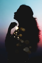 silhouette of woman with bokeh lights