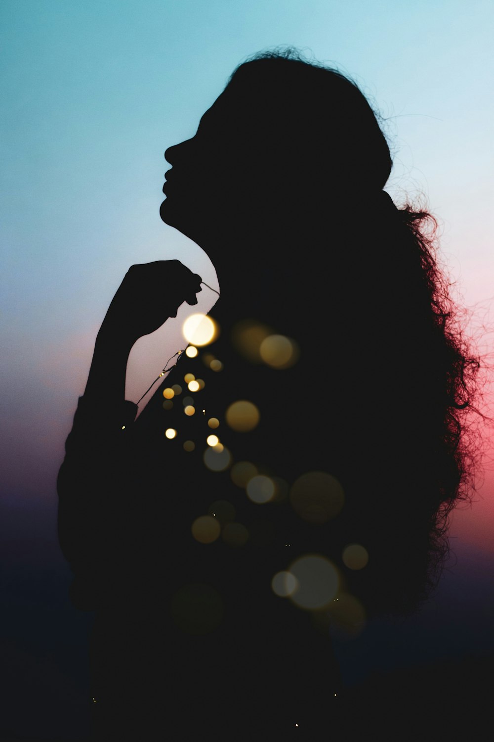silhouette of woman with bokeh lights