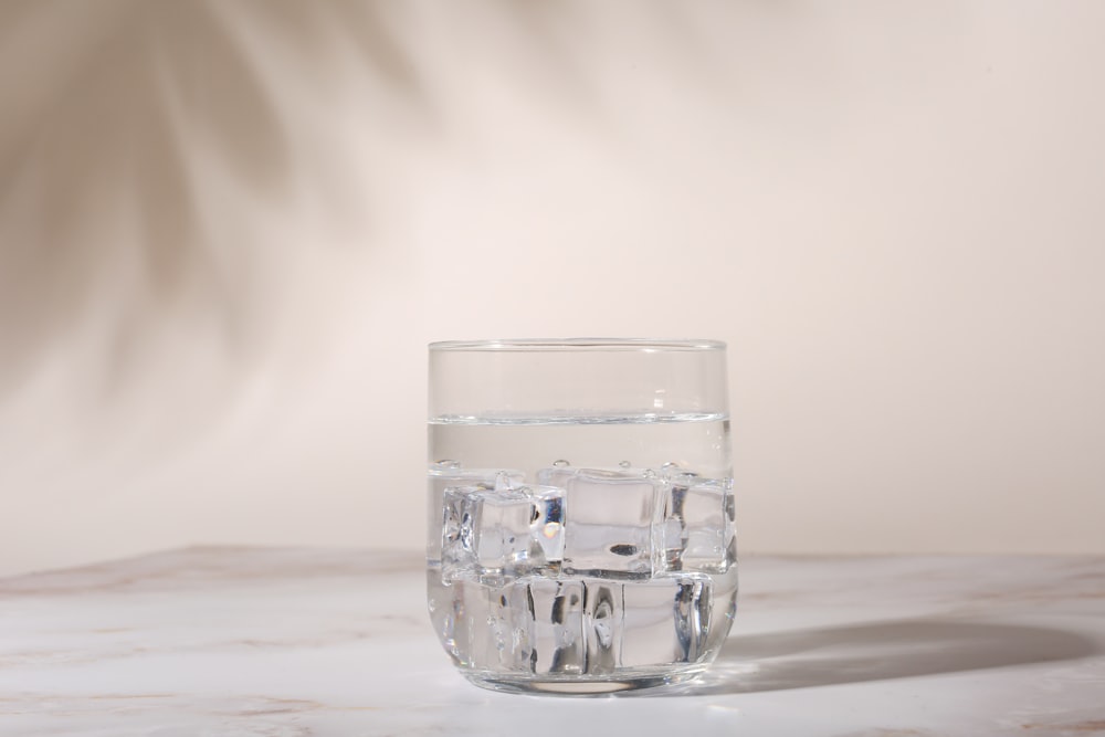 白いテーブルの上の透明なコップ