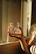Happy family filling glasses with water from a kitchen tap, sunlight streaming in.
