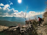 A cheerful family hiking a scenic mountain trail under a clear blue sky