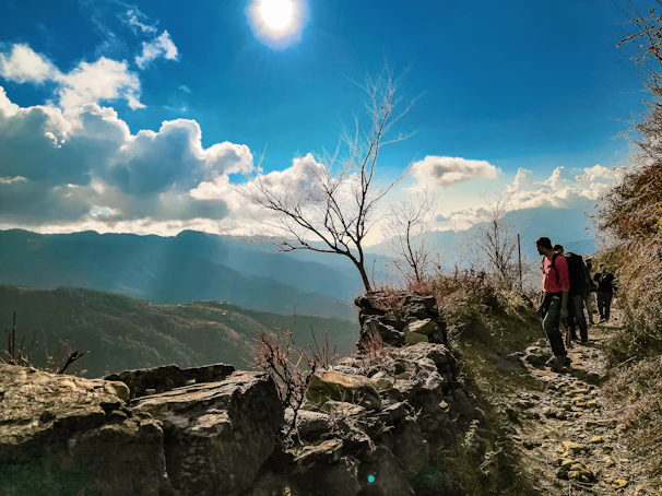 A cheerful family happily exploring a scenic mountain trail during a sunny day trip.