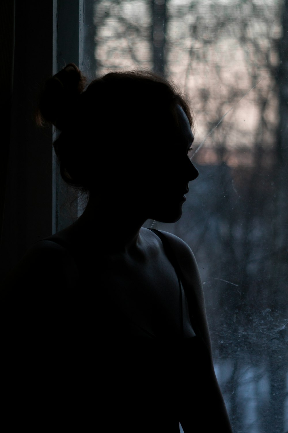 woman in black tank top looking at the window