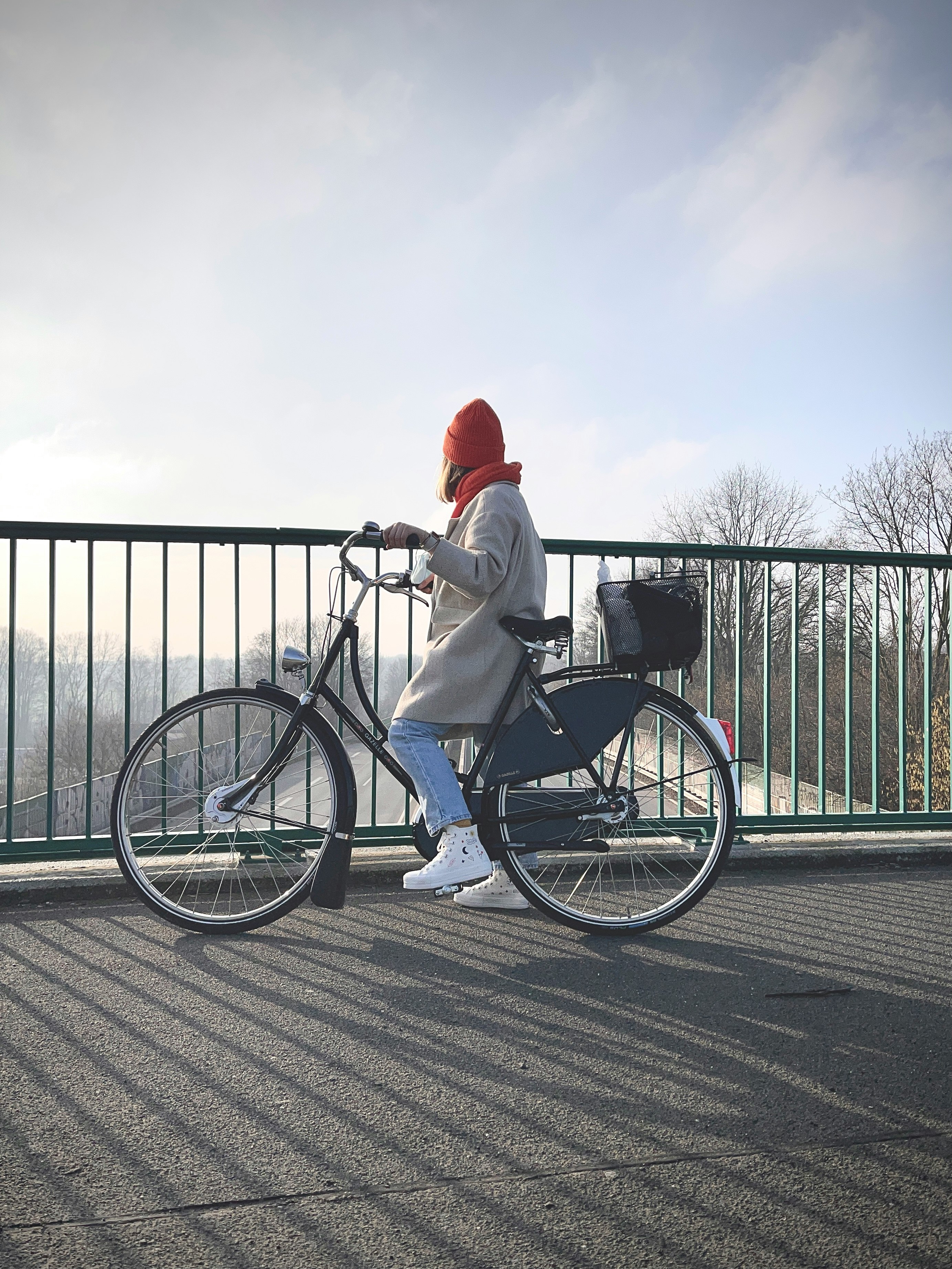 man in white long sleeve shirt and red hat riding on black bicycle