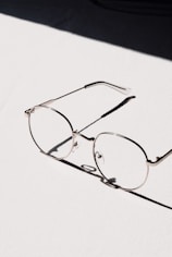 silver framed eyeglasses on white table