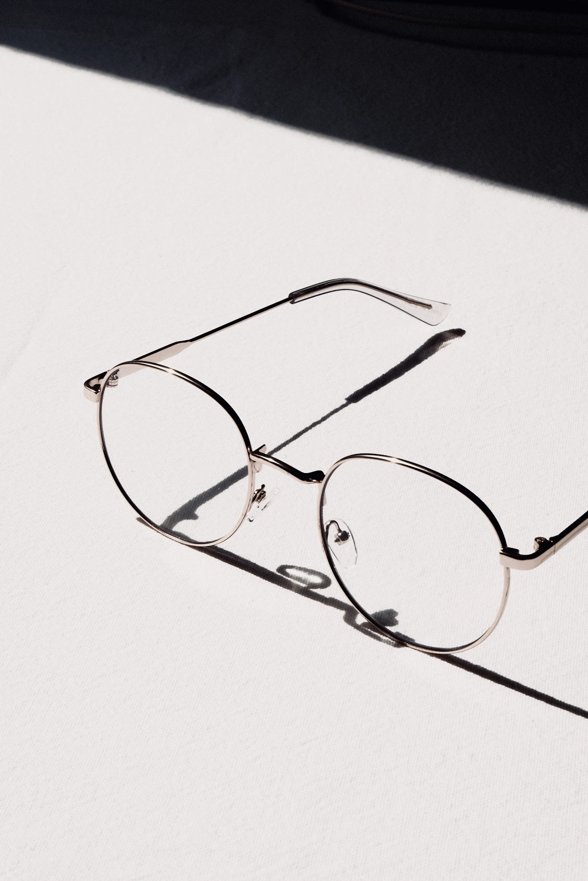 Silver-framed eyeglasses on a white table