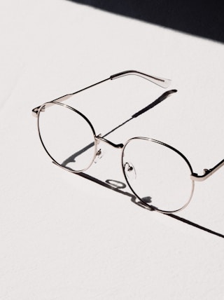 silver framed eyeglasses on white table