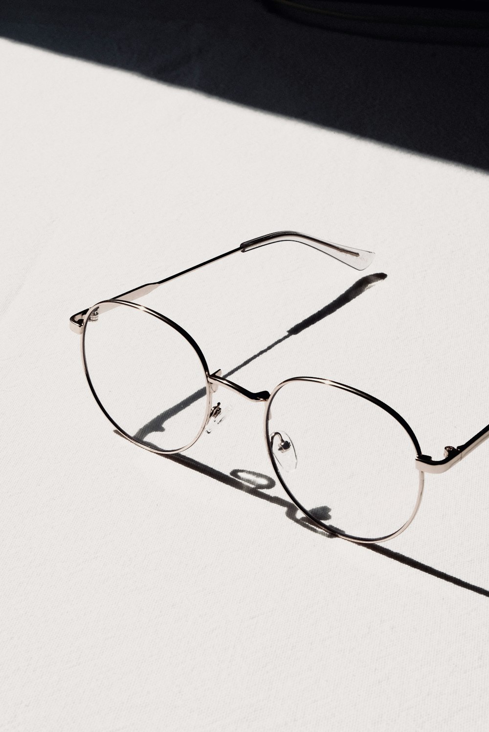 silver framed eyeglasses on white table