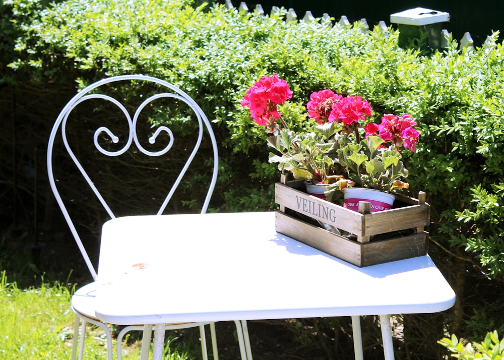 pink flowers on brown wooden box on white table