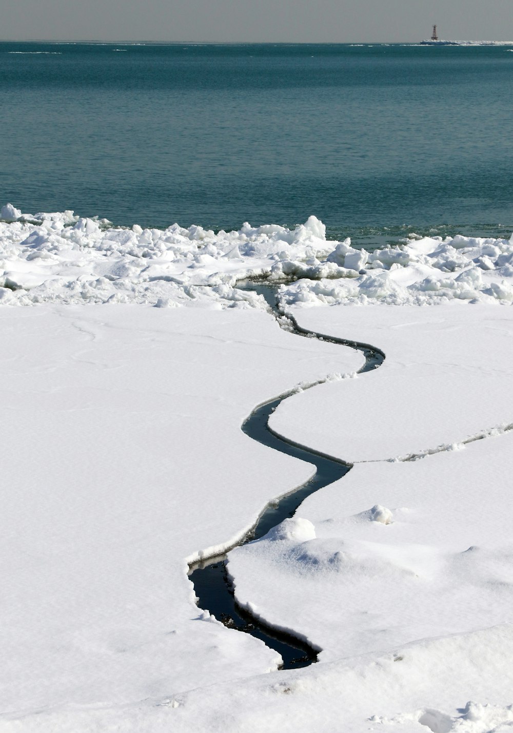 person in black jacket walking on snow covered ground during daytime