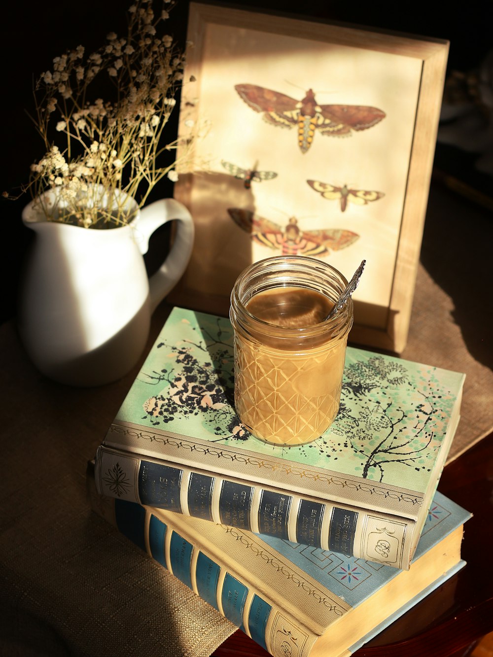 clear glass jar on white and green book