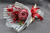 A warm gray sculpture of a small bouquet tied with a dusty rose ribbon, evoking heartfelt sentiments.