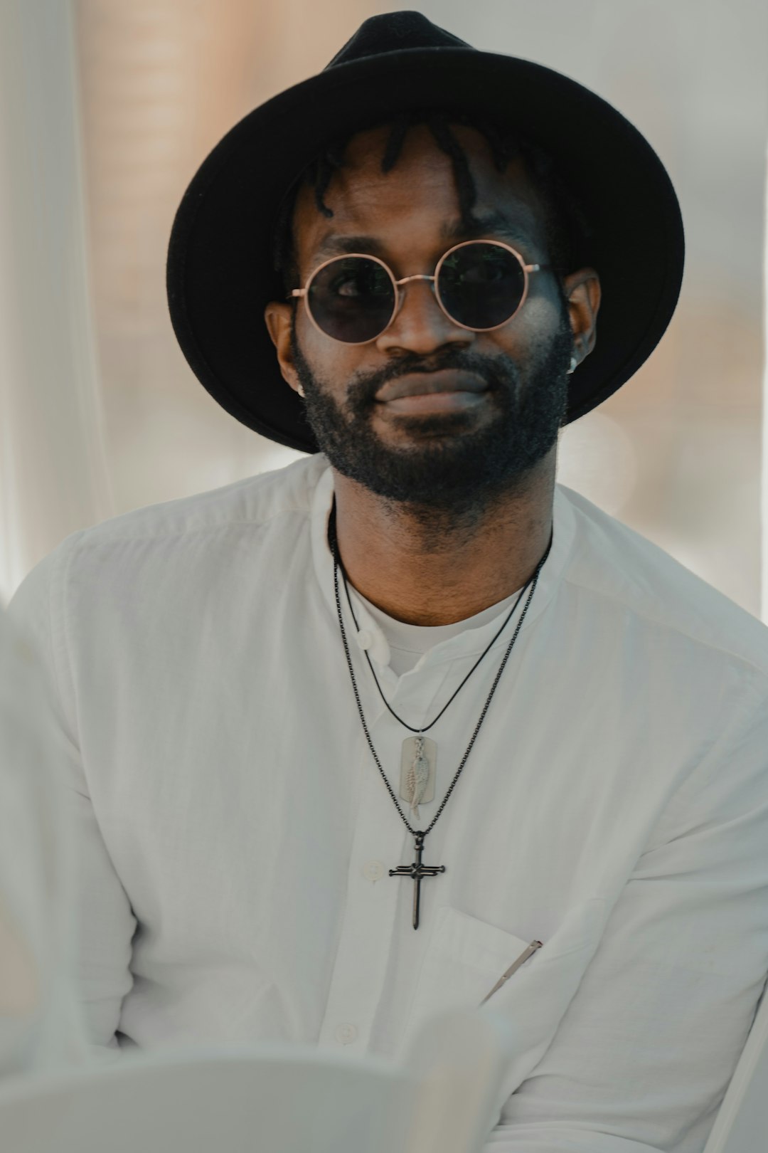 man in white button up shirt wearing black sunglasses and black hat