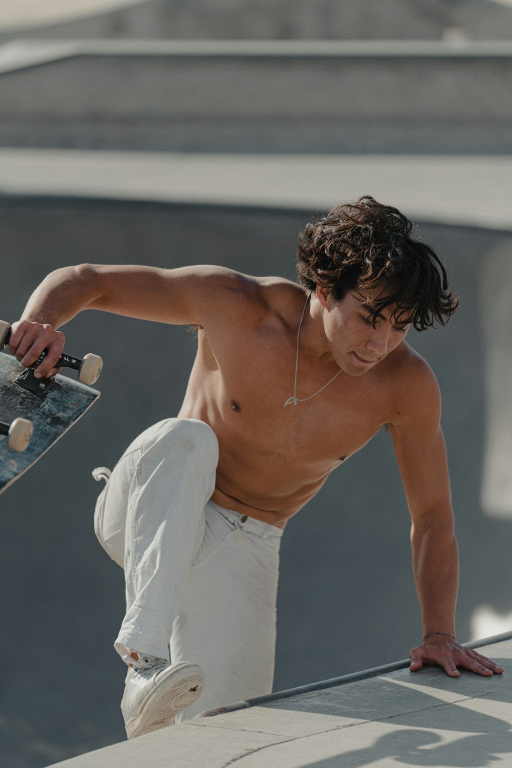 topless man in white pants holding silver iphone 6