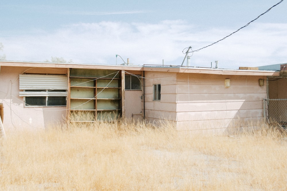 brown wooden house on brown grass field during daytime