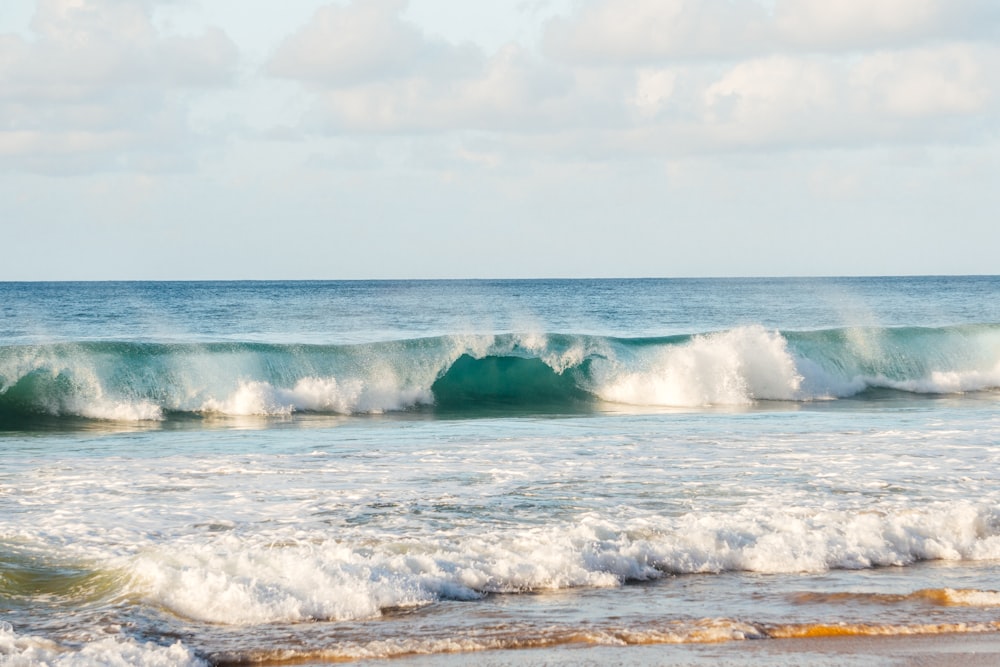 Olas oceánicas bajo nubes blancas durante el día