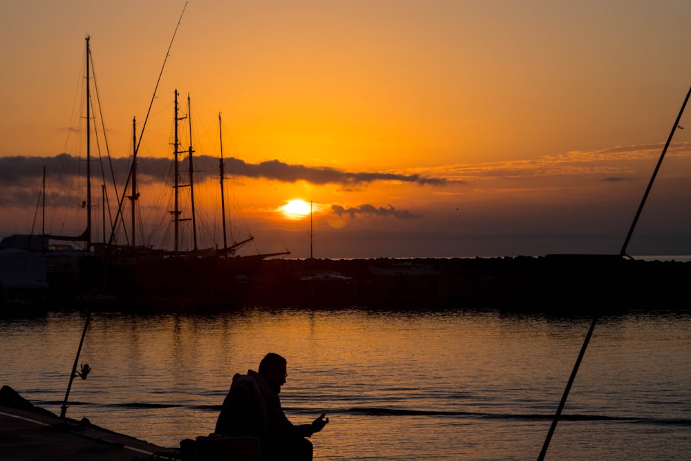 silhouette of man and woman sitting on boat during sunset