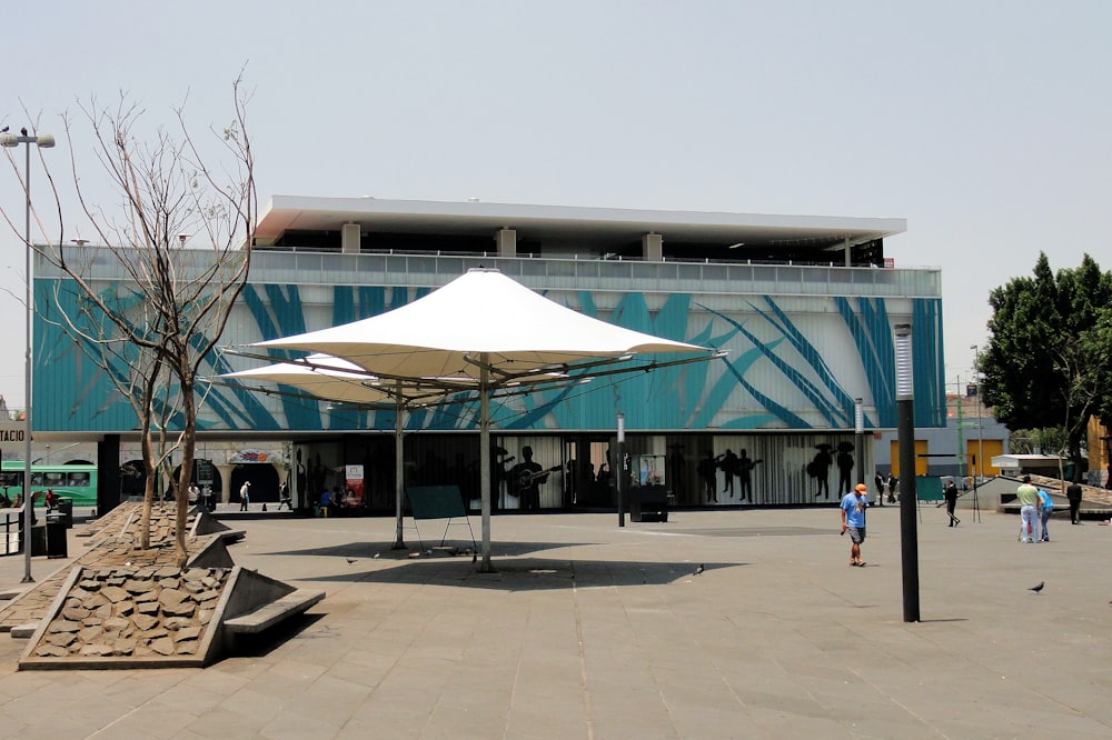 people walking on the street under blue and white roof