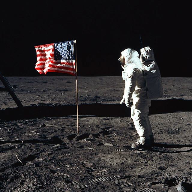 Buzz Aldrin standing on the Moon in front of the United States flag