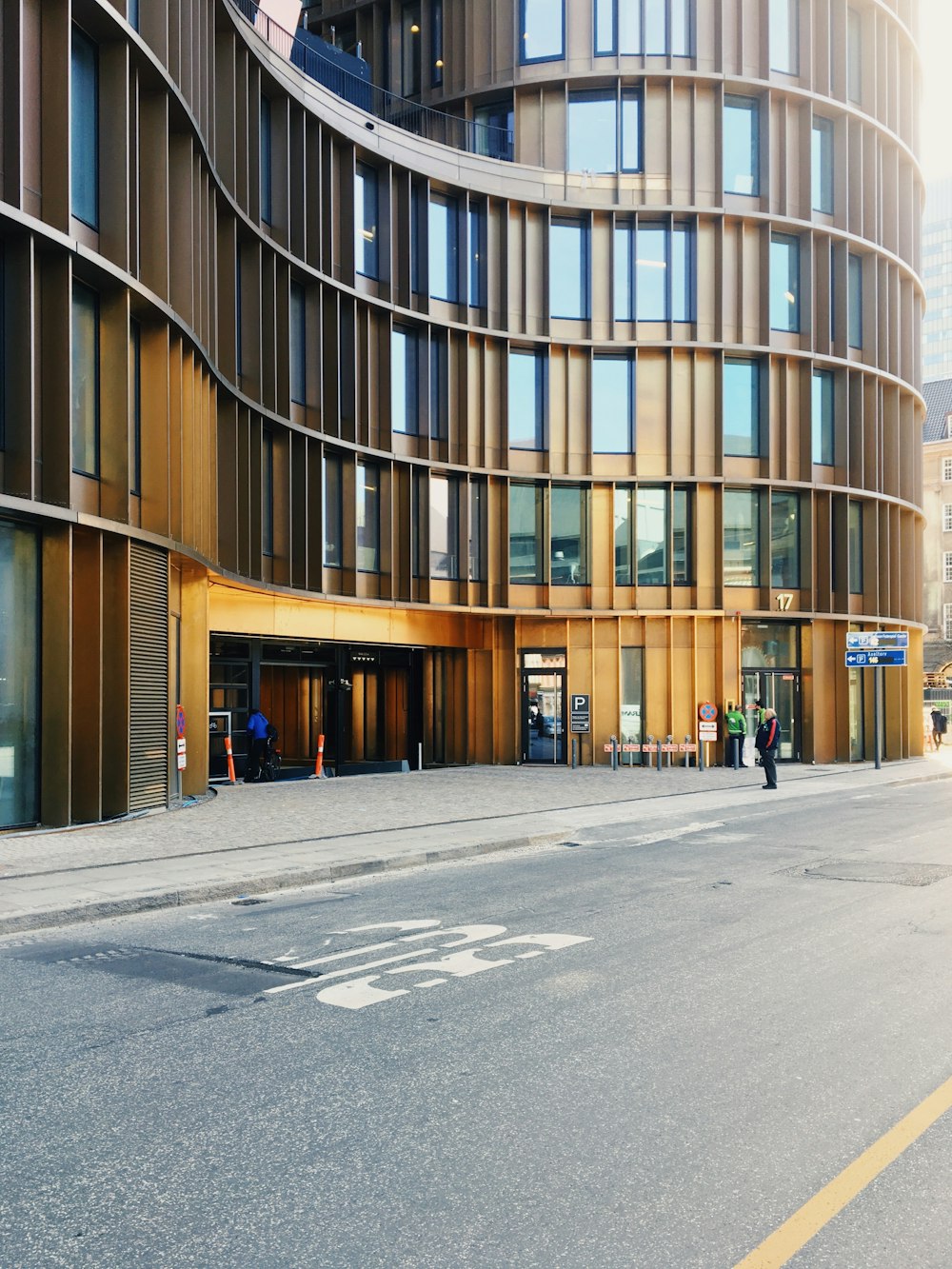 people walking on sidewalk near brown building during daytime