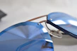 Sleek sunglasses with tinted lenses displayed on a sandy beach background.