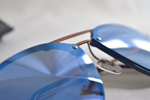 Close-up of sleek blue optical frames displayed on a white surface.