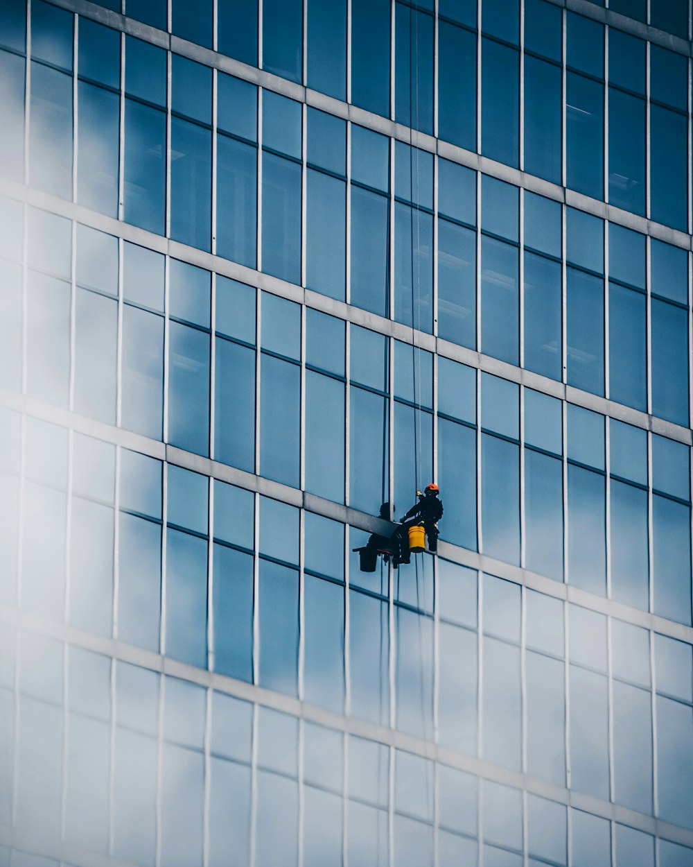 man in black jacket and black pants sitting on the window