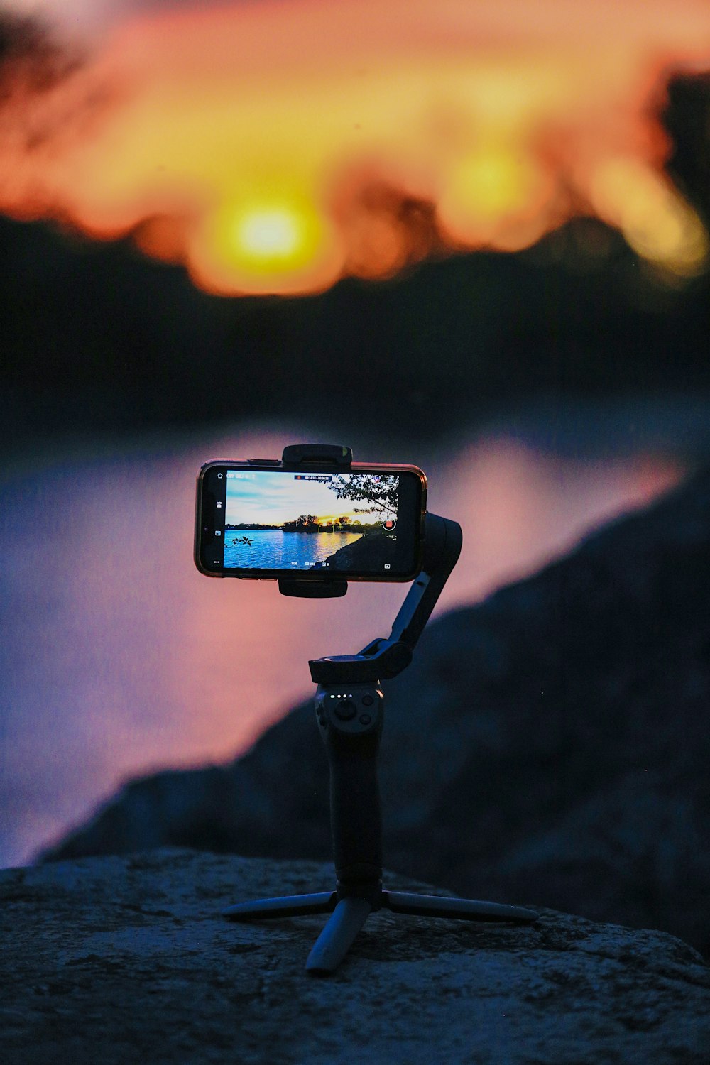 black and silver camera taking photo of sunset