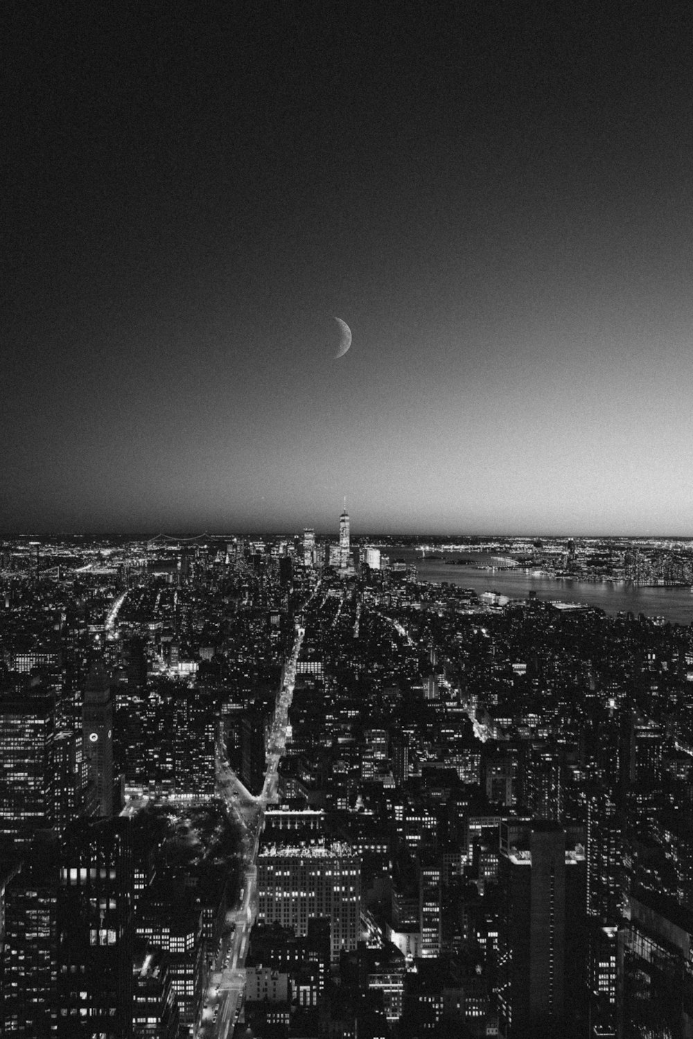 Foto en escala de grises de los edificios de la ciudad durante la noche