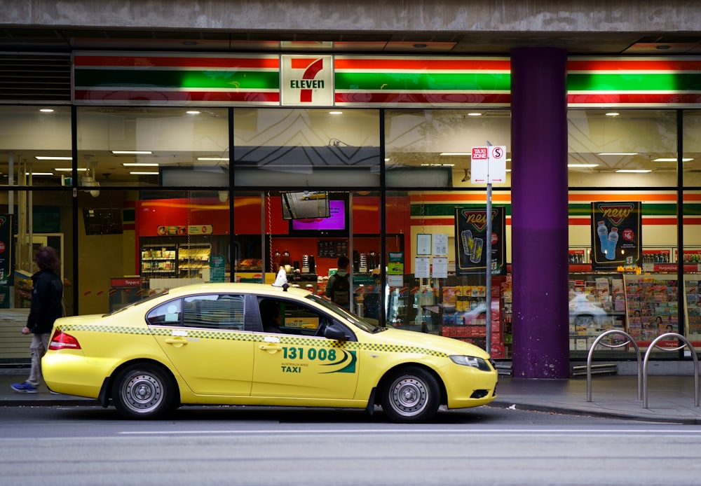 yellow taxi cab in front of store during night time