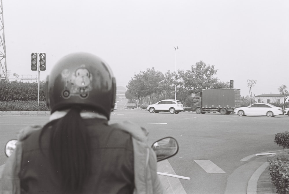 grayscale photo of man in jacket standing on road