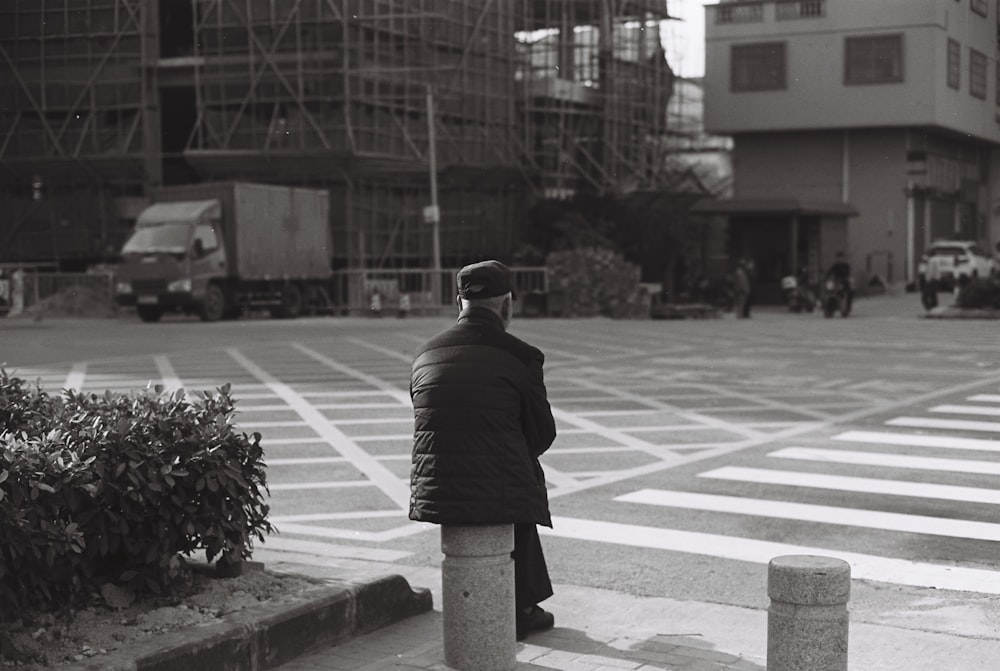 man in black jacket standing on pedestrian lane during daytime