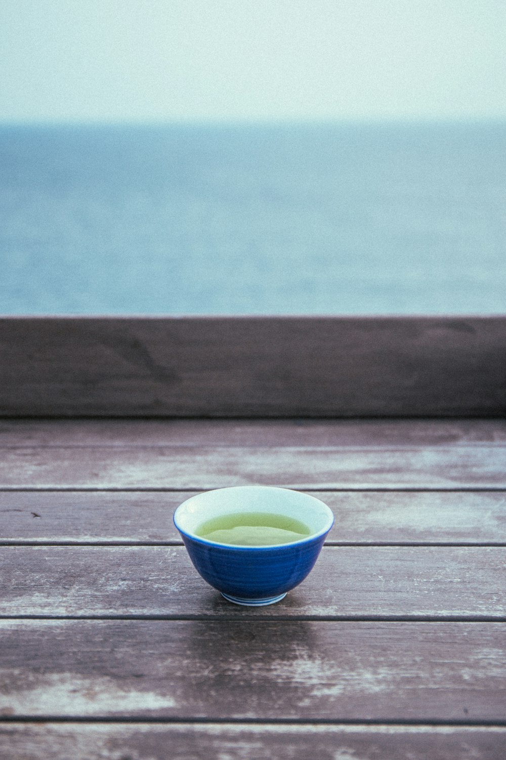 blue ceramic bowl on brown wooden table