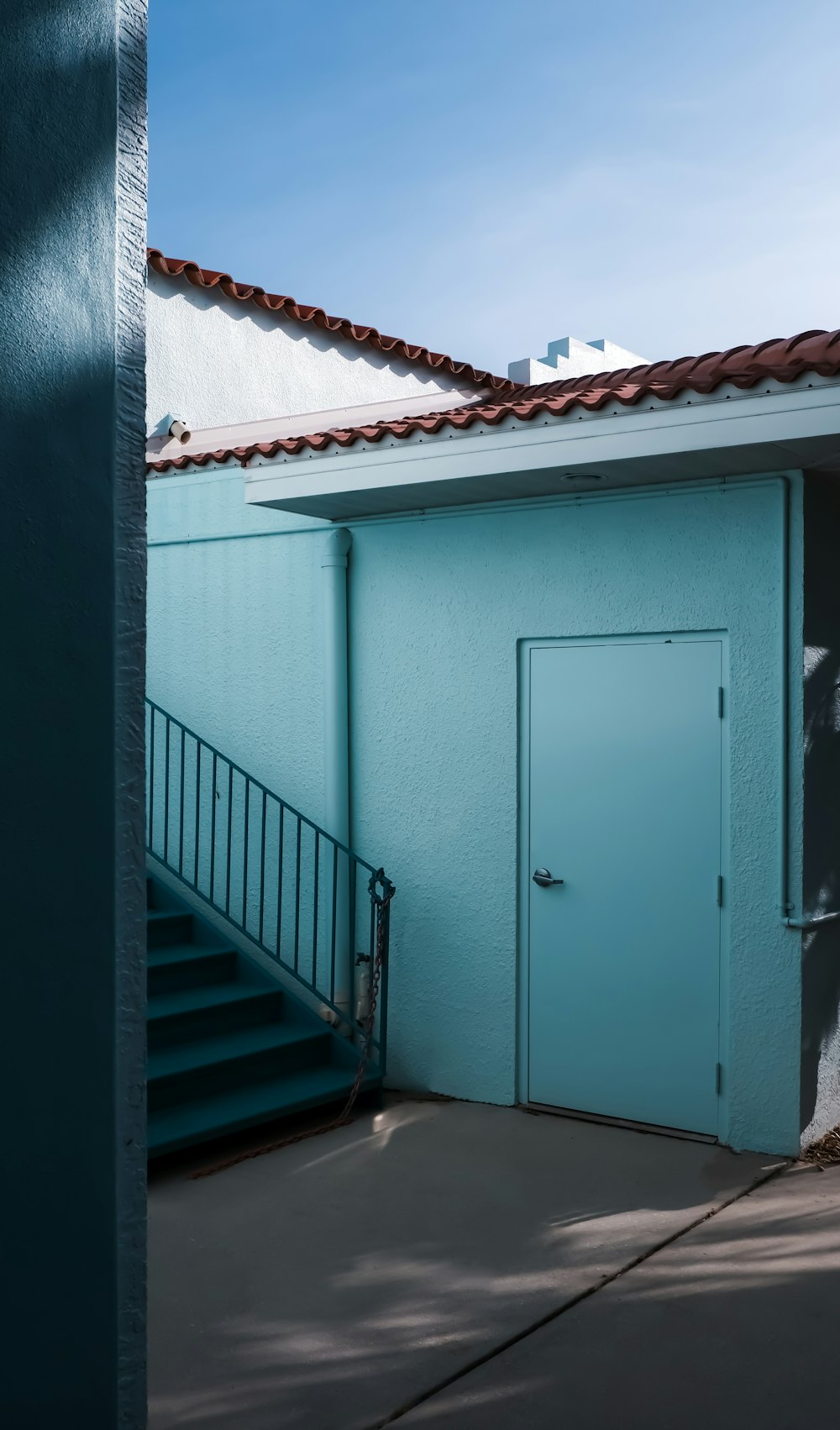 blue wooden door on white concrete wall