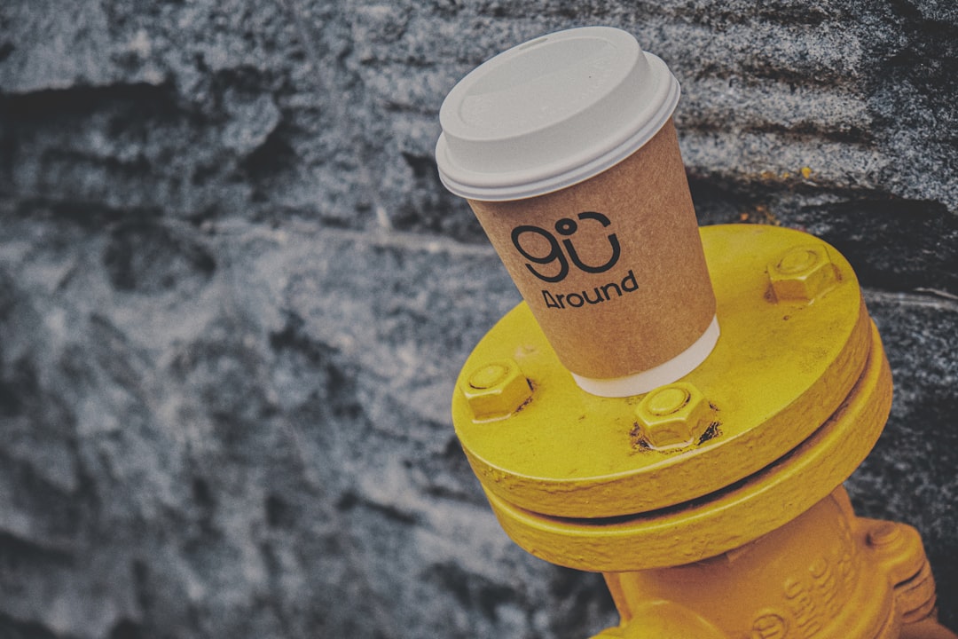 white and brown coffee cup on yellow plastic cup holder