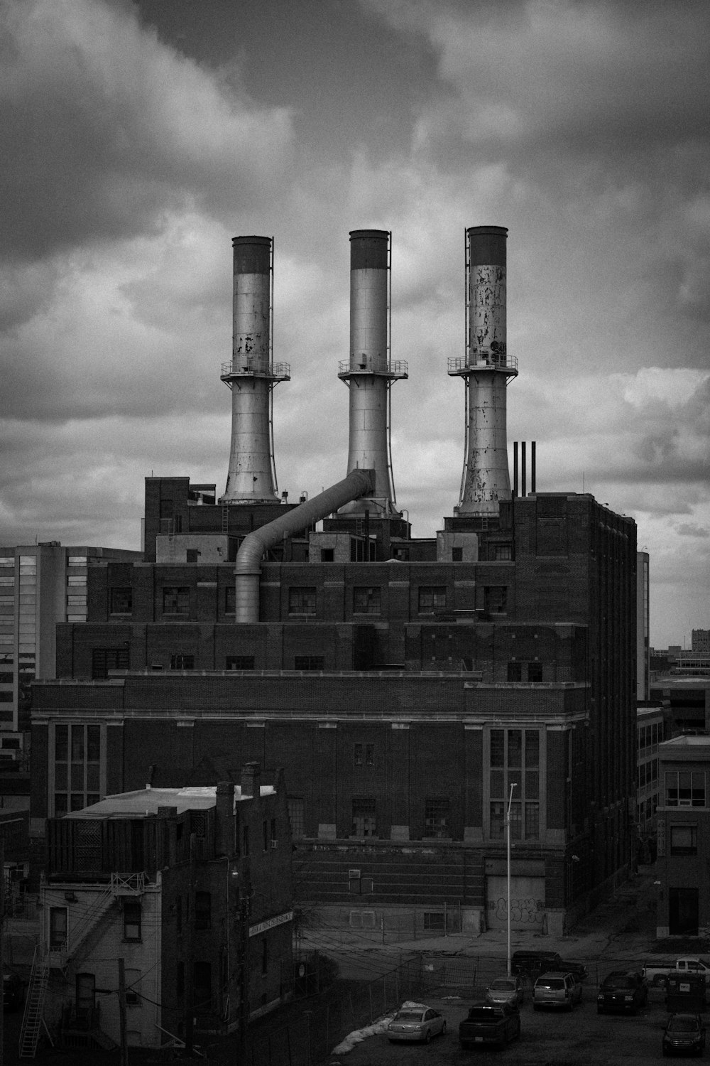 grayscale photo of city buildings under cloudy sky