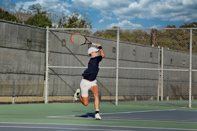 Athlete in mid-motion executing a powerful tennis serve under clear blue sky.