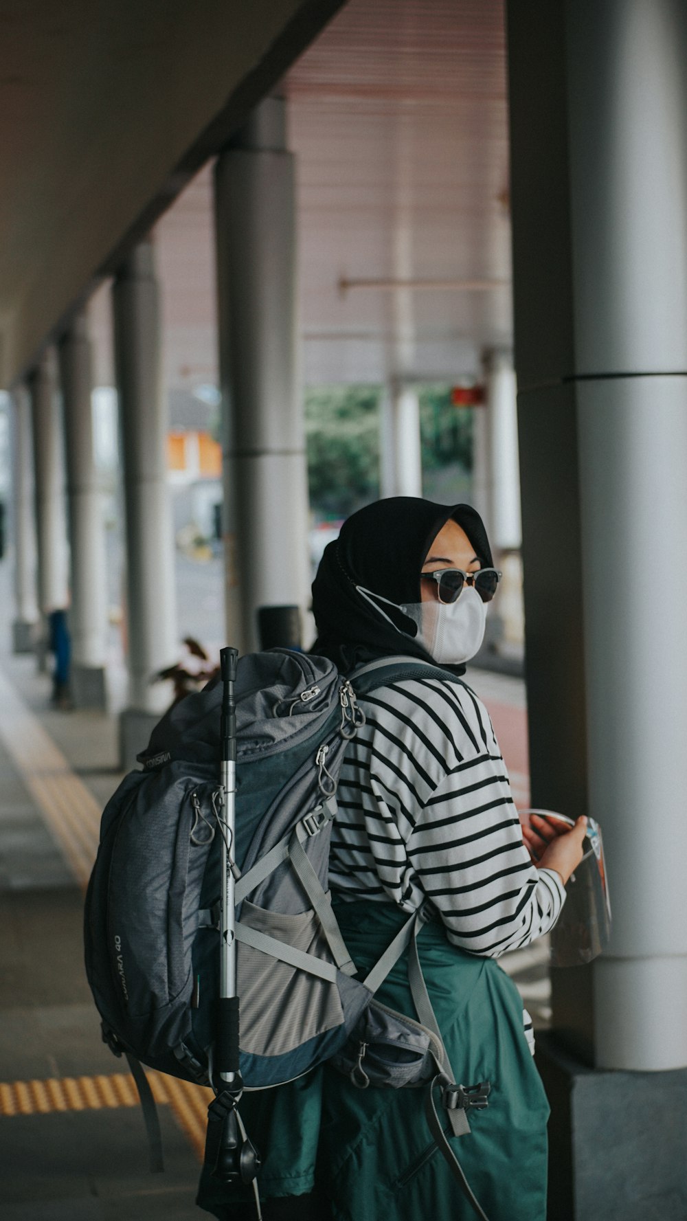 Femme en chemise à manches longues à rayures noires et blanches portant un hijab noir